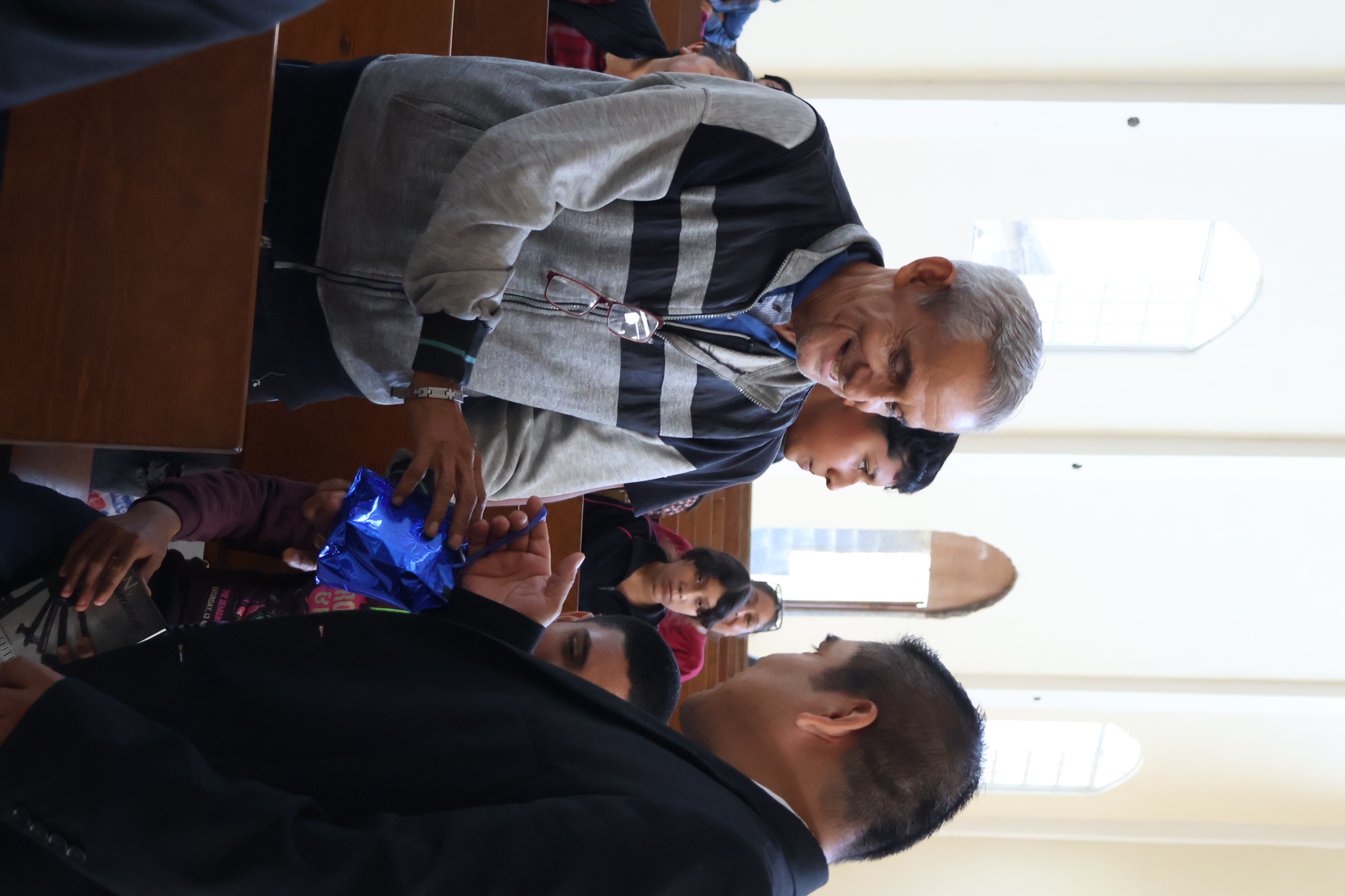 Un miembro de la iglesia entrega un obsequio a un visitante por primera vez